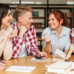 Grupa czworga młodych ludzi dyskutujących przy stole