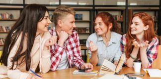 Grupa czworga młodych ludzi dyskutujących przy stole