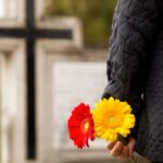 Mężczyzna z kwiatami na cmentarzu