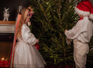 Jarmark Bożonarodzeniowy Chłopic i dziewczynka ubierają choinkę