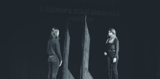 Dwie kobiety na scenie teatralnej tworzą wrażenie odbicia lustrzanego