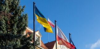 widok na urząd miejski w Kwidzynie oraz maszty z flagami - od lewej: Ukrainy, Polski, Unii Europejskiej