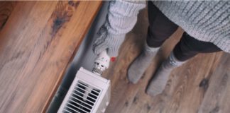 Kobieta stoi przy kaloryferze