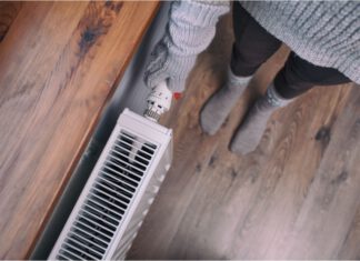 Kobieta stoi przy kaloryferze