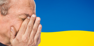 twarz zrozpaczonego mężczyzny na tle flagi Ukrainy