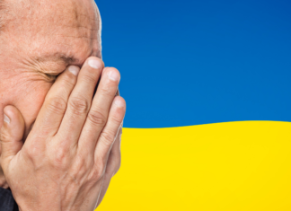 twarz zrozpaczonego mężczyzny na tle flagi Ukrainy