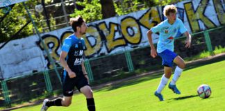 dwóch zawodników biegnie za piłką