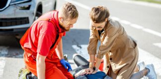 mężczyzna i kobieta udzielają pierwszej pomocy poszkodowanemu w ypadku