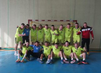 zadowolona drużyna piłki ręcznej pozuje do zdjęcia przed bramką