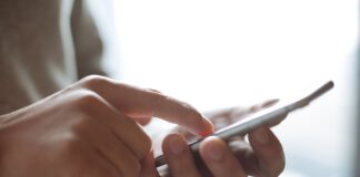 dłonie trzymają telefon komórkowy
