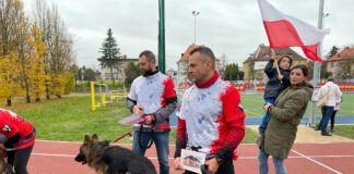 Dorośli i dzieci na bieżni, dziecko na ręku u mamy z flagą Polski