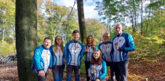 zawodnicy z medalami pozują do zdjęcia w lesie