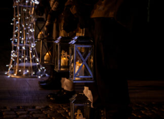 na pierwszym planie uczestnicy miejskiej wigilii 2022, w tle kinoteatr i plac Jana Pawła II