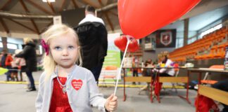 mała dziewczynka w czerwonej sukience z balonem