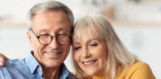 starsza kobieta i mężczyzna wpatrzeni w telefon komórkowy.