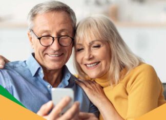 starsza kobieta i mężczyzna wpatrzeni w telefon komórkowy.