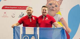 dwóch mężczyzn na podium z flagą Kwidzyna