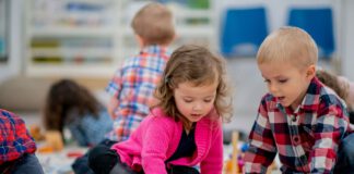 przedszkolaki bawią się klockami na podłodze