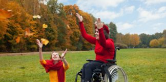 Dwie dziewczyny podrzucają do góry liście