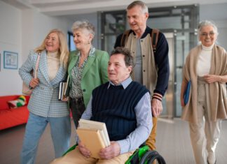 grupa zadowolonych seniorów na korytarzu