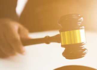 Drugi przetarg ustny nieograniczony – ul. Malborska dłoń trzymająca młotek w geście przebijania ofert