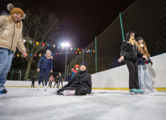 Lodowisko jest w formie :) Zabawa dzieci i młodzieży na lodowisku. Rozśmiana dziewczyna w centrum