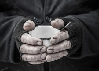Zbliżają się mroźne dni. Widzisz bezdomnych? Pomóż! zdjęcie ilustracyjne, zbliżenie na dłonie trzymające kubek